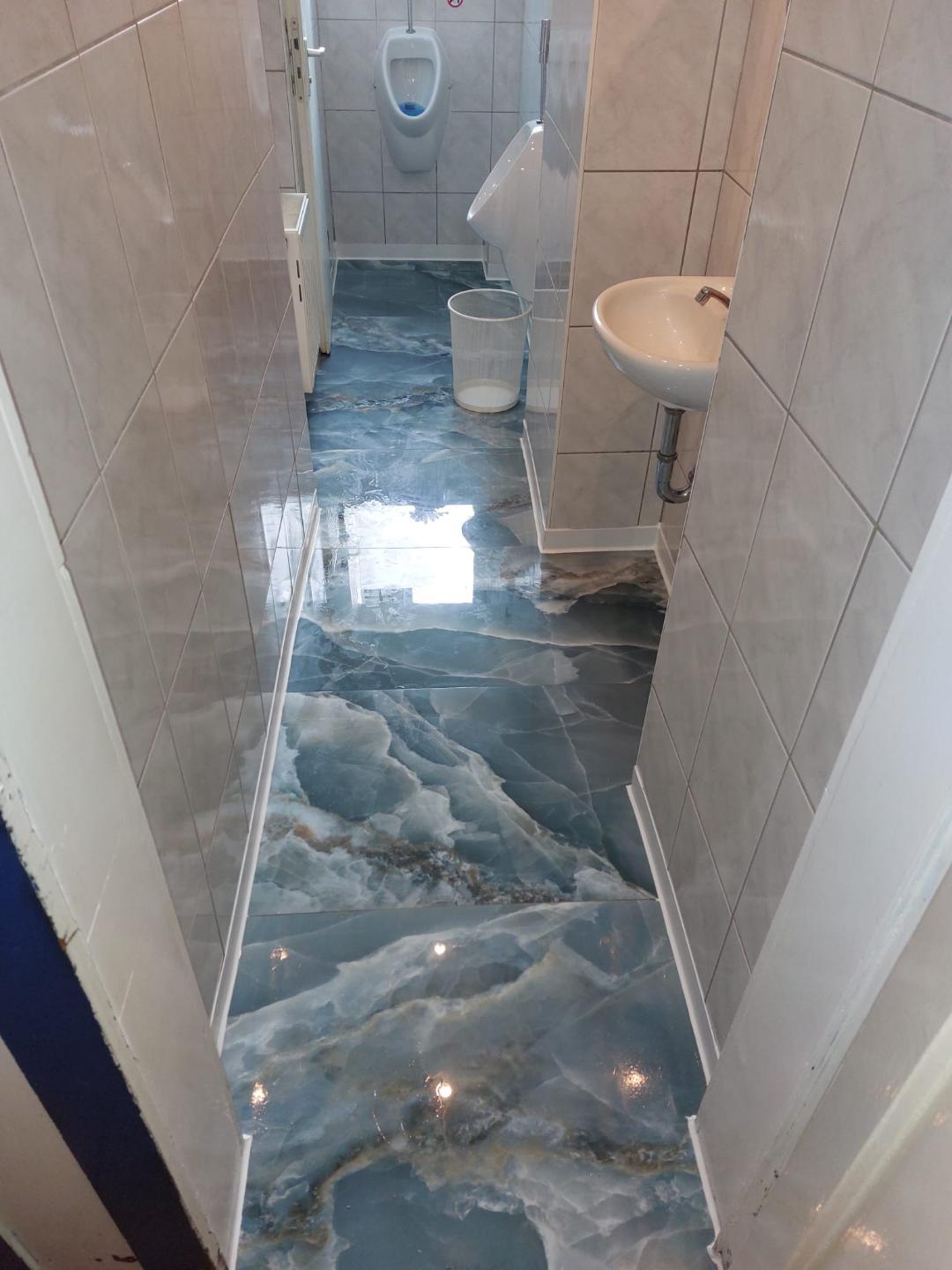 Saniertes Gäste-WC mit glänzendem Designboden in Marmoroptik